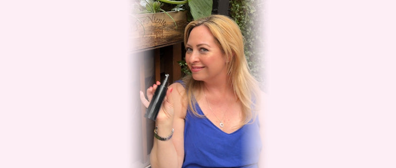 Sarah Fendrich holding her setting spray in her garden